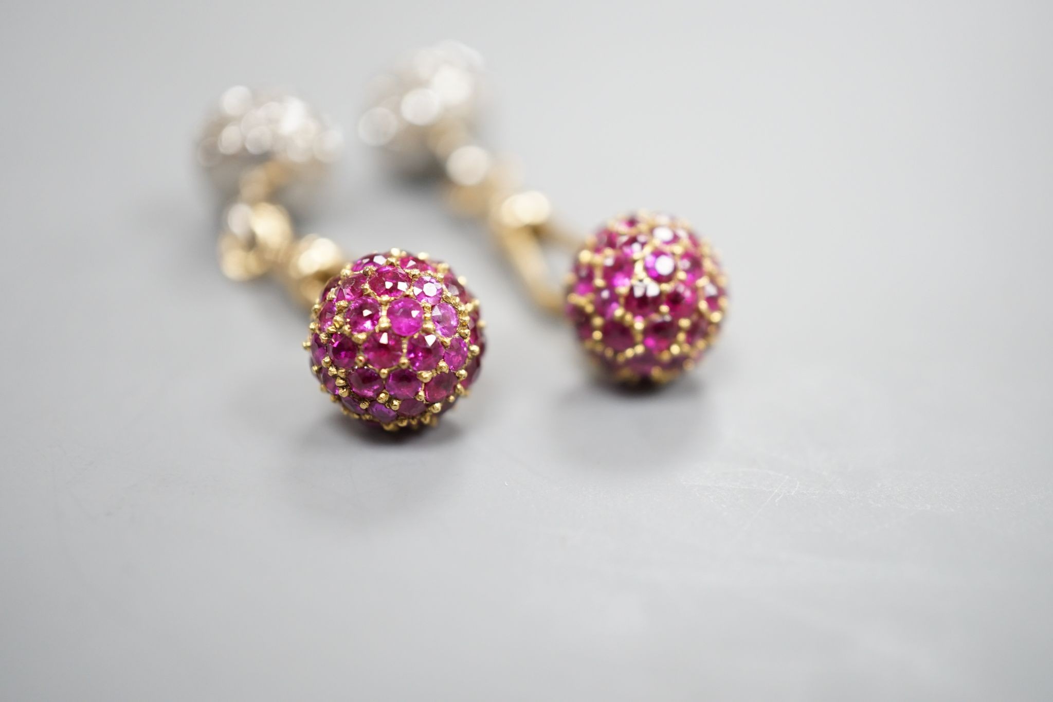 A pair of yellow metal and pave set ruby and diamond cufflinks (adapted), gross weight 10 grams.